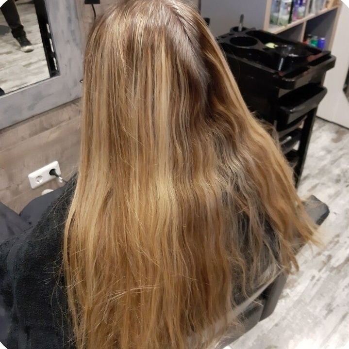Hetzelfde lange haar na het kleuren, egaal warm blond